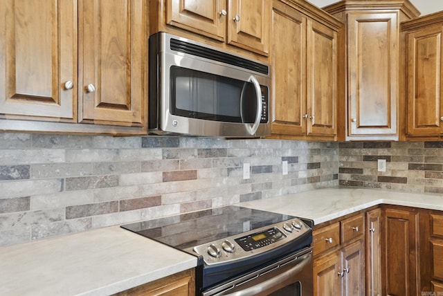 5400 Montgomery Rd, Little Rock, AR 72223 - kitchen with stainless steel appliances, tasteful backsplash, brown cabinets, and light countertops