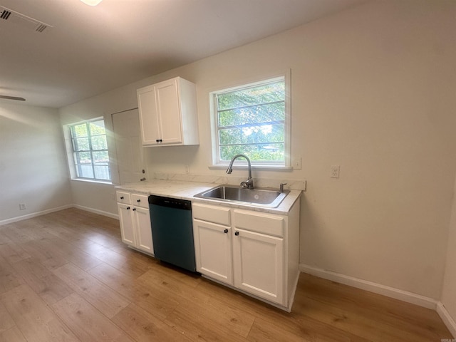 3003 Hollywood St, Texarkana, TX 75503 - kitchen featuring dishwasher, a sink, light wood finished floors, light countertops, and white cabinetry