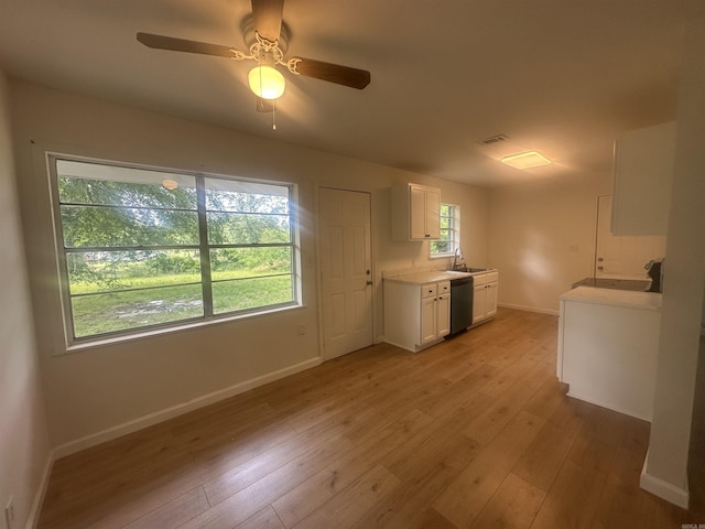 3003 Hollywood St, Texarkana, TX 75503 - kitchen with dishwasher, white cabinets, light wood-type flooring, a sink, and baseboards