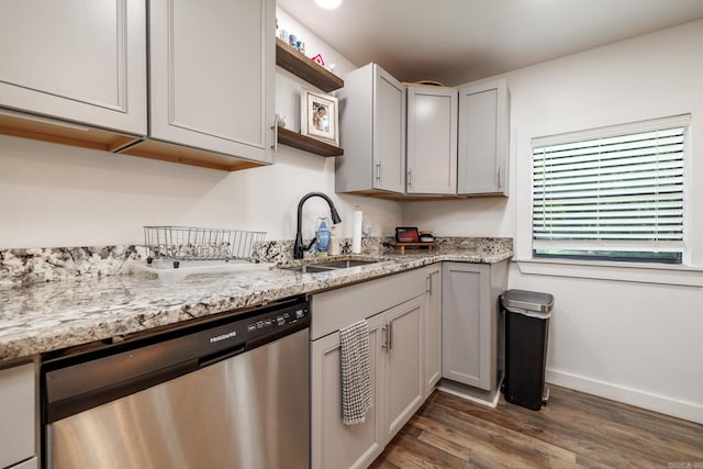1647 Gresham St, Arkadelphia, AR 71923 - kitchen with stainless steel dishwasher, a sink, wood finished floors, baseboards, and light stone counters