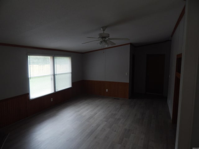 505 Main, West Point, AR 72178 - spare room featuring wainscoting, ceiling fan, wood finished floors, ornamental molding, and wooden walls