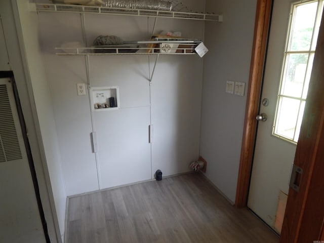 505 Main, West Point, AR 72178 - laundry area featuring wood finished floors, healthy amount of natural light, a heating unit, and washer hookup