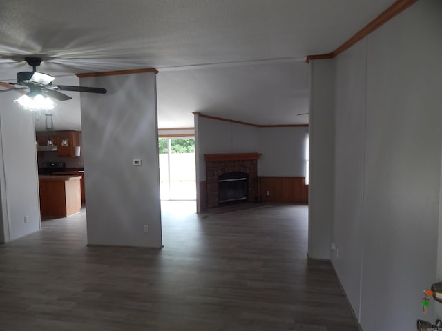 505 Main, West Point, AR 72178 - unfurnished living room featuring dark wood-style floors, ceiling fan, ornamental molding, a wainscoted wall, and a brick fireplace