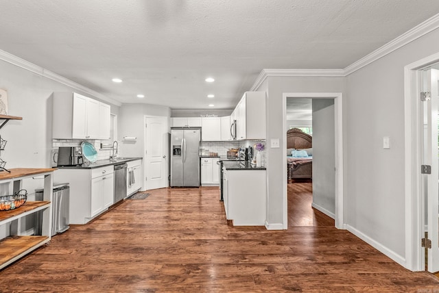 7110 Forest Dale Dr, North Little Rock, AR 72118 - kitchen featuring stainless steel appliances, a sink, ornamental molding, dark countertops, and backsplash