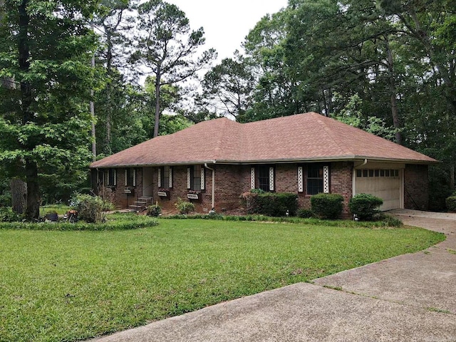 single story home featuring concrete driveway, a garage, a front yard, brick siding, and roof with shingles