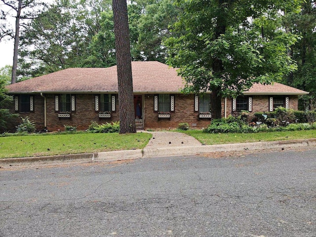 view of front of home with brick siding and a front yard