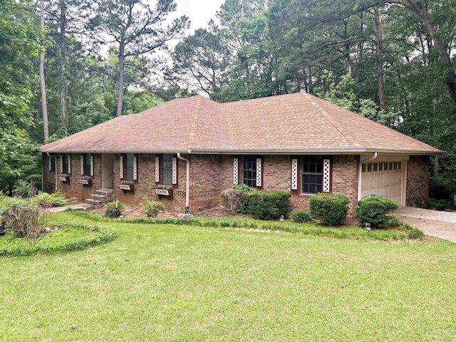 ranch-style house featuring a front lawn, an attached garage, brick siding, driveway, and roof with shingles