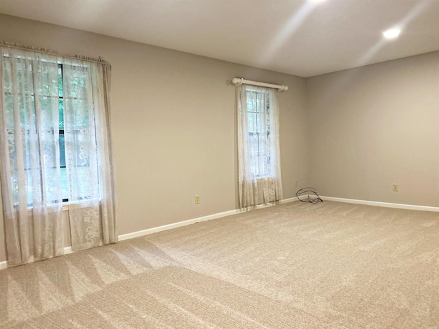 spare room featuring carpet flooring and baseboards