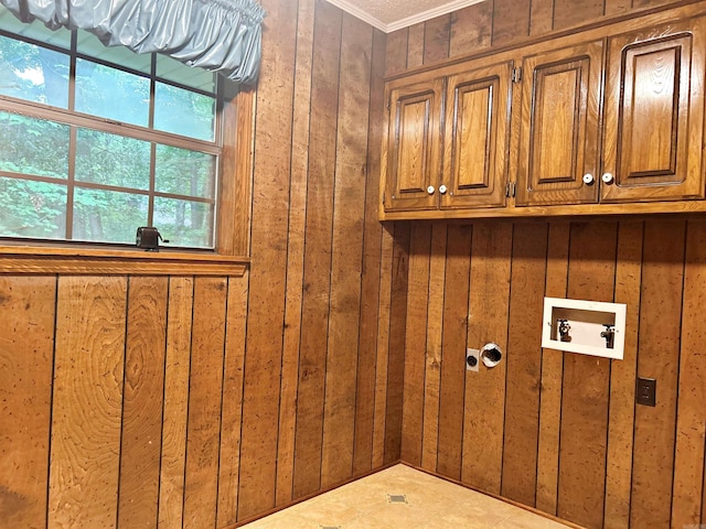 laundry area with cabinet space, crown molding, washer hookup, and wood walls