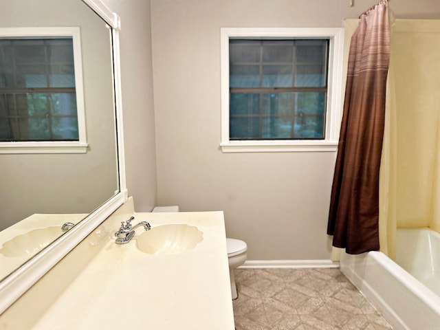 full bath featuring toilet, shower / tub combo, vanity, and baseboards