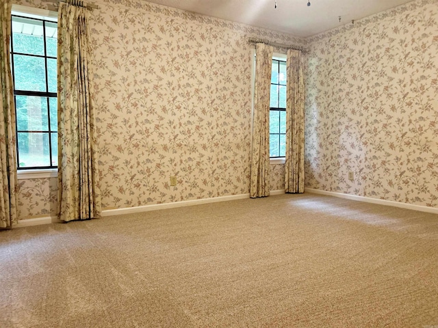 carpeted empty room with wallpapered walls and baseboards