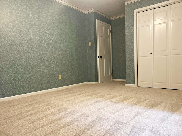 unfurnished bedroom featuring carpet, a closet, and baseboards