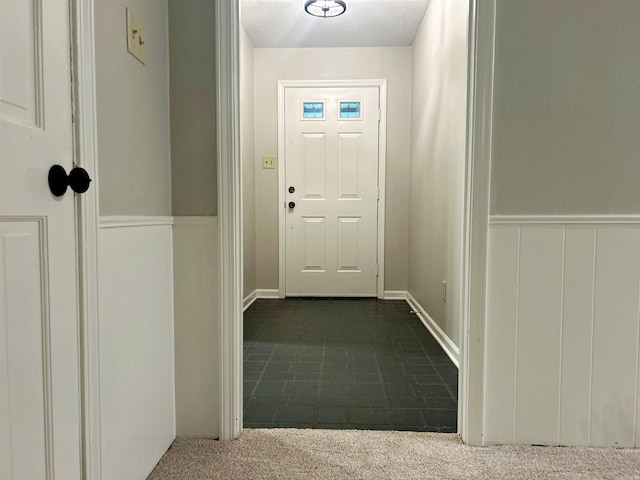entryway with dark carpet