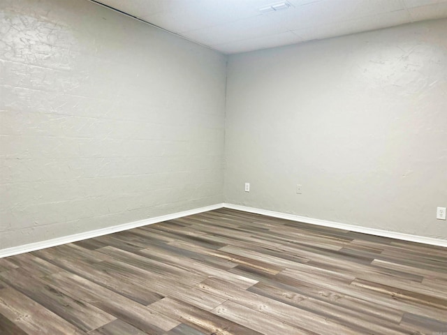 empty room featuring baseboards and wood finished floors