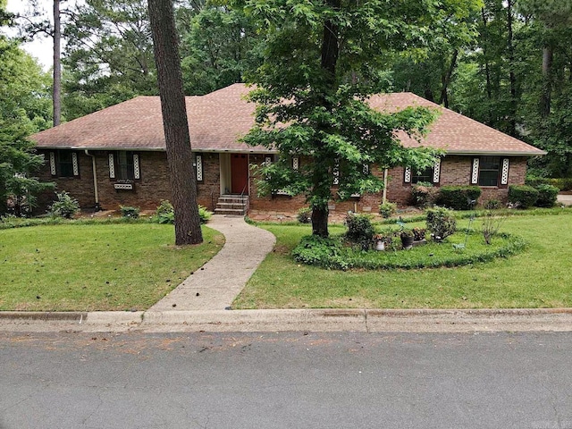 ranch-style home featuring a front lawn, brick siding, and a shingled roof