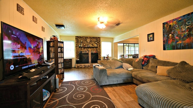 514 Proft Cir, Mena, AR 71953 - living room featuring wood finished floors, a textured ceiling, and a fireplace