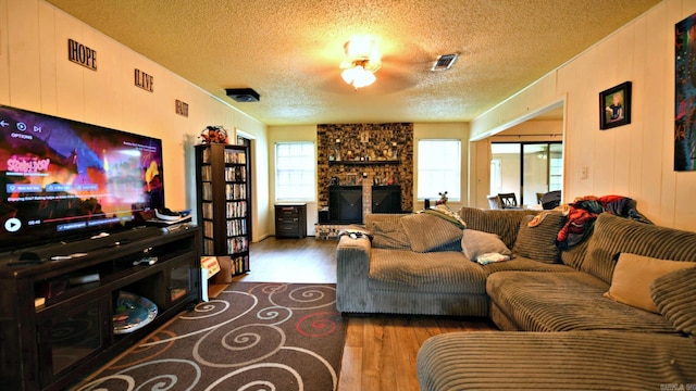 514 Proft Cir, Mena, AR 71953 - living area with wood finished floors, a textured ceiling, and a fireplace