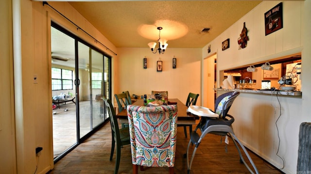 514 Proft Cir, Mena, AR 71953 - dining space with a chandelier, a textured ceiling, and dark wood-style flooring
