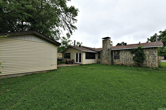 514 Proft Cir, Mena, AR 71953 - back of property with a yard, a chimney, french doors, and an outbuilding