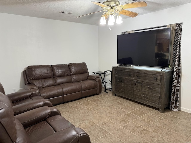 living area featuring ceiling fan, a textured ceiling, and light tile patterned floors