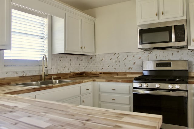312 S Crossroads, Portia, AR 72457 - kitchen featuring stainless steel appliances, wood counters, a sink, tasteful backsplash, and white cabinets