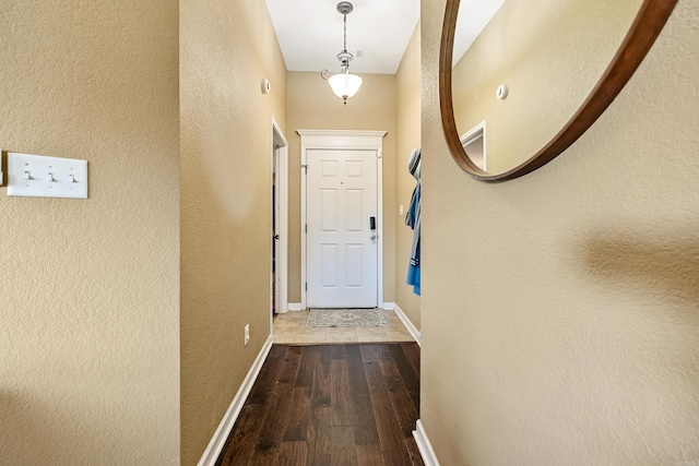 doorway with hardwood / wood-style floors and baseboards