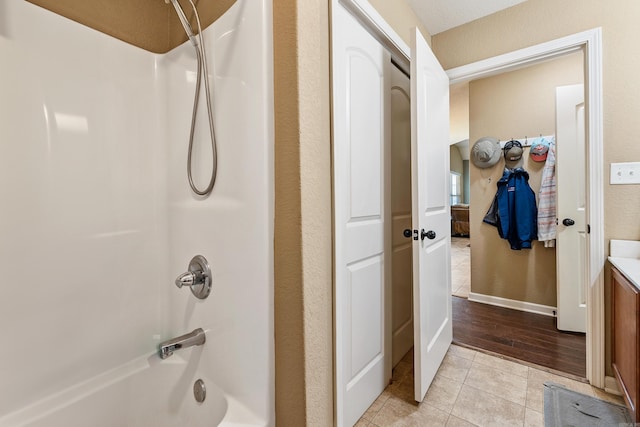 full bath with tub / shower combination, vanity, and tile patterned flooring