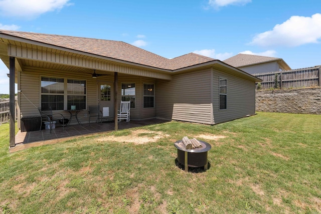 back of house with an outdoor fire pit, a patio, and a shingled roof