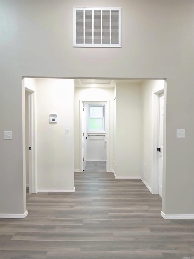 corridor featuring baseboards and wood finished floors