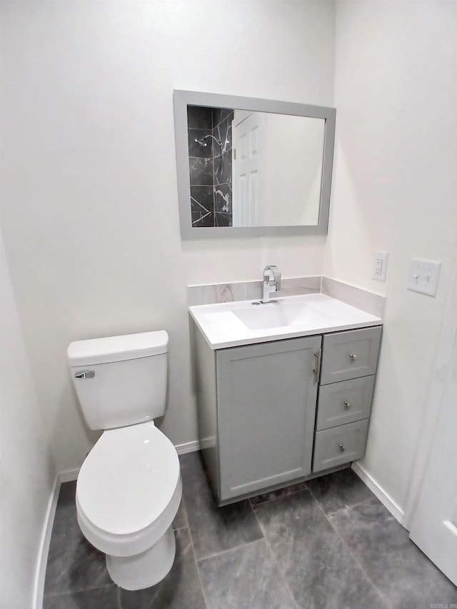 bathroom with vanity, baseboards, and toilet