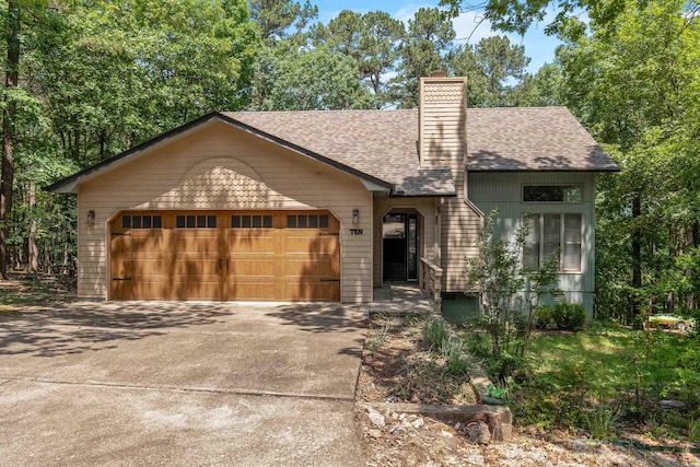 10 Balenciaga Way, Hot Springs Village, AR 71909 - view of front of home featuring driveway, an attached garage, a chimney, and a shingled roof