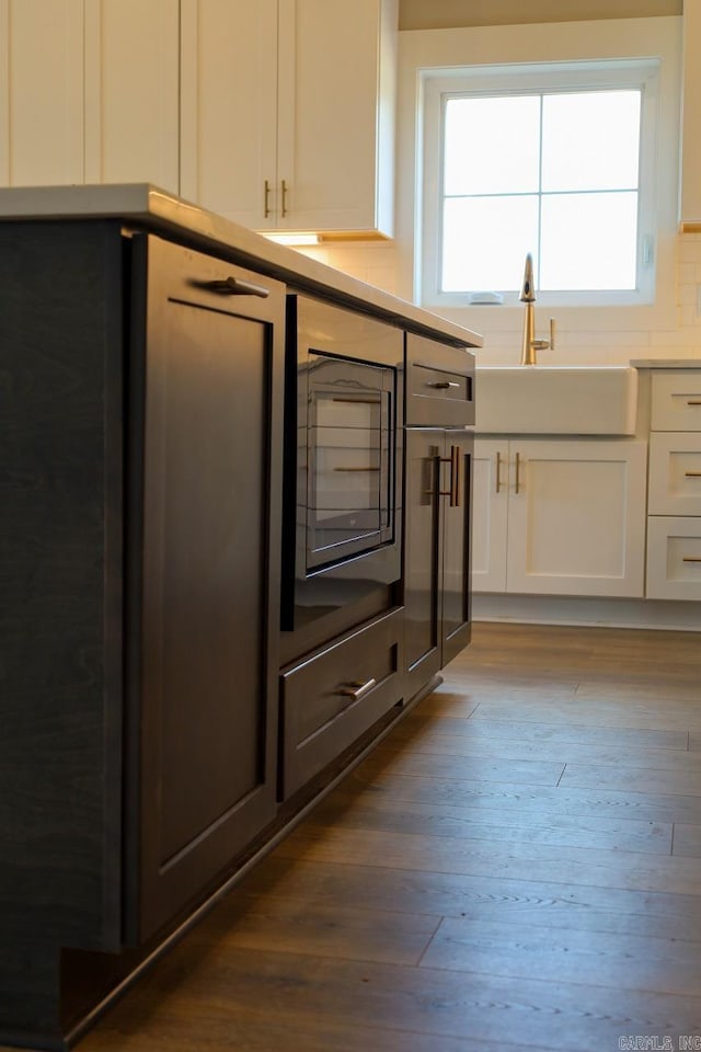 111 Legacy Way, Ward, AR 72176 - kitchen with white cabinetry, dark wood-style flooring, a sink, and light countertops