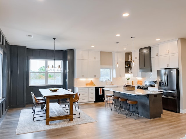 111 Legacy Way, Ward, AR 72176 - kitchen featuring stainless steel fridge, gas stove, a kitchen island, a sink, and light countertops