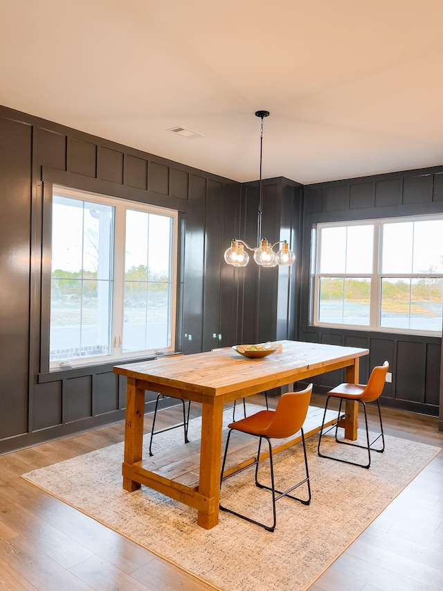111 Legacy Way, Ward, AR 72176 - dining room with light wood-style flooring, a decorative wall, and a chandelier