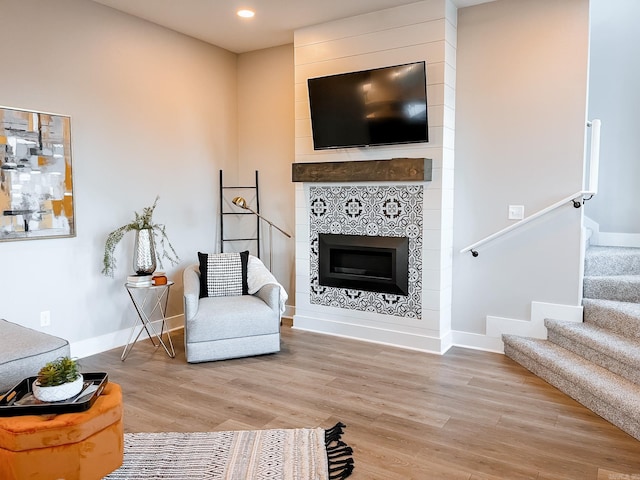 111 Legacy Way, Ward, AR 72176 - living area featuring light wood-style flooring, stairs, baseboards, a tile fireplace, and recessed lighting