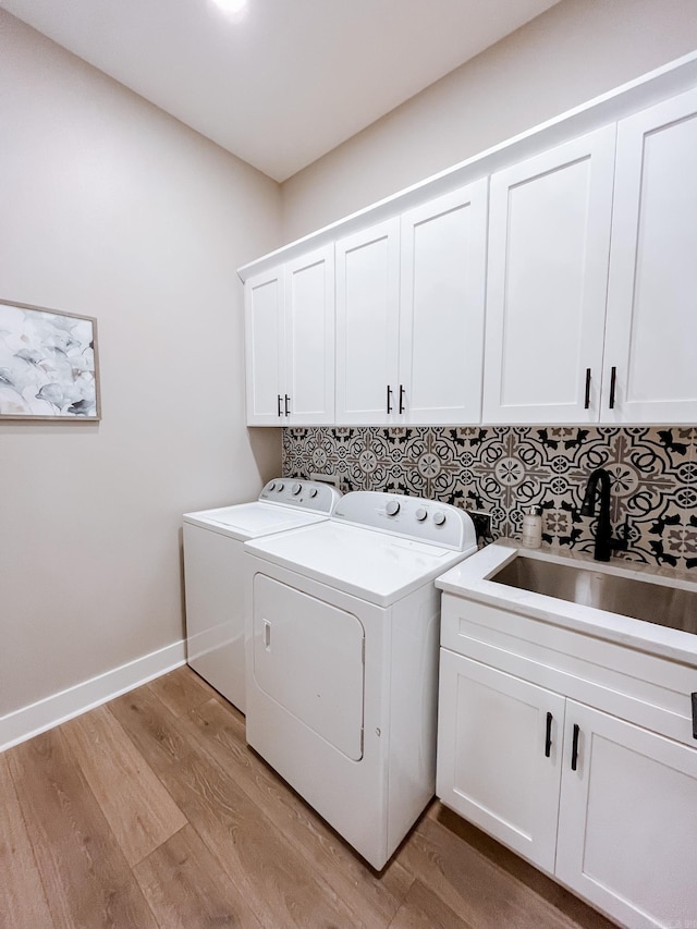 111 Legacy Way, Ward, AR 72176 - laundry area featuring washing machine and clothes dryer, cabinet space, light wood-style flooring, and baseboards