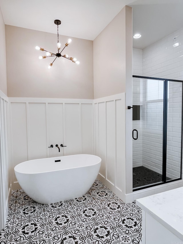 111 Legacy Way, Ward, AR 72176 - bathroom with a decorative wall, a freestanding bath, a chandelier, a shower stall, and vanity