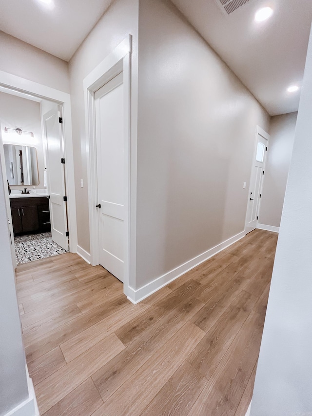 111 Legacy Way, Ward, AR 72176 - corridor featuring light wood finished floors, baseboards, recessed lighting, and a sink
