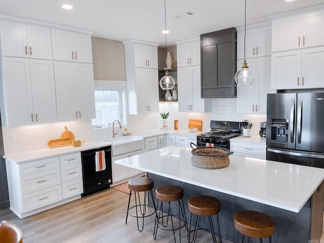 111 Legacy Way, Ward, AR 72176 - kitchen featuring black appliances, a sink, a breakfast bar, a kitchen island, and recessed lighting