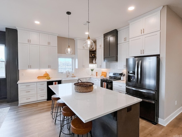 111 Legacy Way, Ward, AR 72176 - kitchen featuring black appliances, light wood-type flooring, backsplash, white cabinetry, and recessed lighting