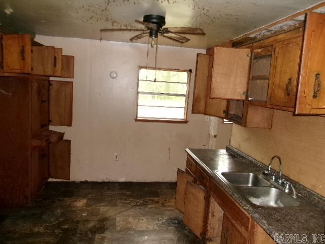 1321 Cherry Ln, Malvern, AR 72104 - kitchen featuring a sink, brown cabinets, ceiling fan, and dark countertops