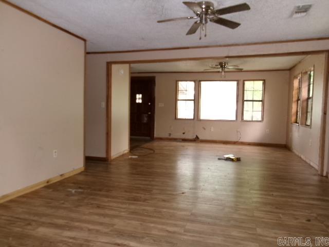 1321 Cherry Ln, Malvern, AR 72104 - spare room featuring ceiling fan, wood finished floors, baseboards, and a textured ceiling