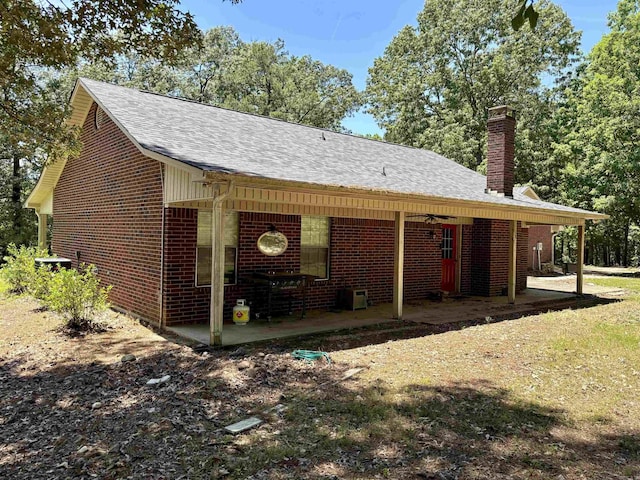 177 Timberlane, Dierks, AR 71833 - view of property exterior featuring a patio, a chimney, brick siding, and roof with shingles