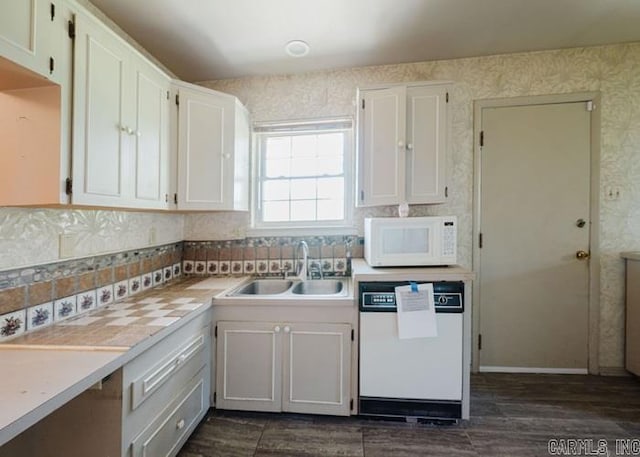 kitchen with white appliances, a sink, dark wood-type flooring, light countertops, and wallpapered walls