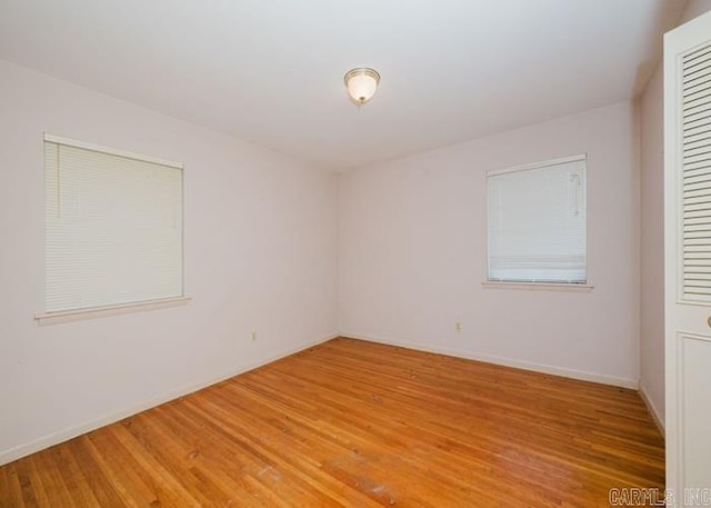 spare room with light wood-style flooring and baseboards