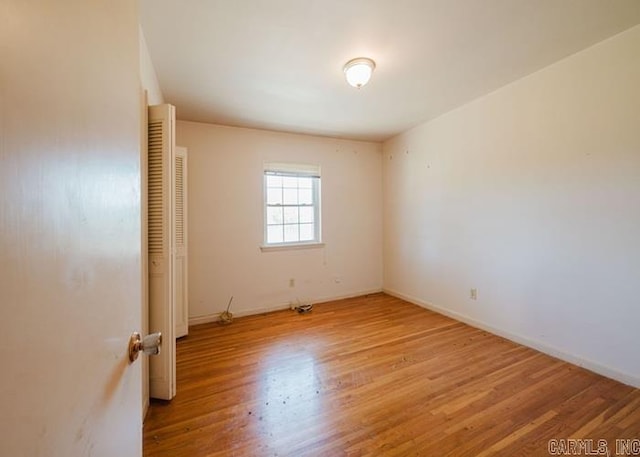 spare room featuring wood finished floors and baseboards