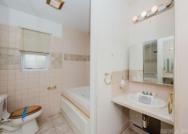 bathroom with tile walls, toilet, a bath, tile patterned flooring, and a sink