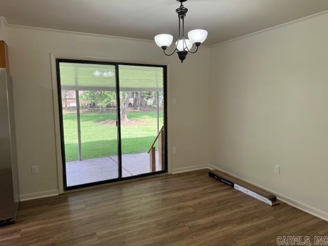 2275 Victory Ln, Conway, AR 72032 - unfurnished dining area featuring a chandelier, ornamental molding, dark wood-style flooring, and baseboards