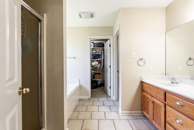 2960 Windamere Dr, Conway, AR 72034 - bathroom with vanity, a spacious closet, a garden tub, tile patterned floors, and baseboards