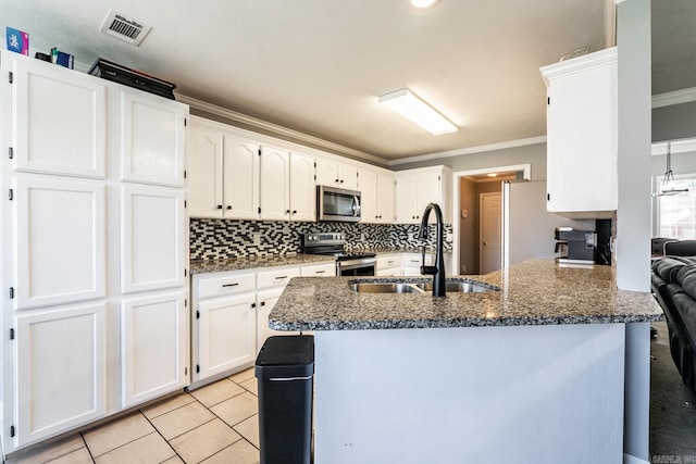2960 Windamere Dr, Conway, AR 72034 - kitchen with appliances with stainless steel finishes, a sink, crown molding, white cabinetry, and dark stone counters